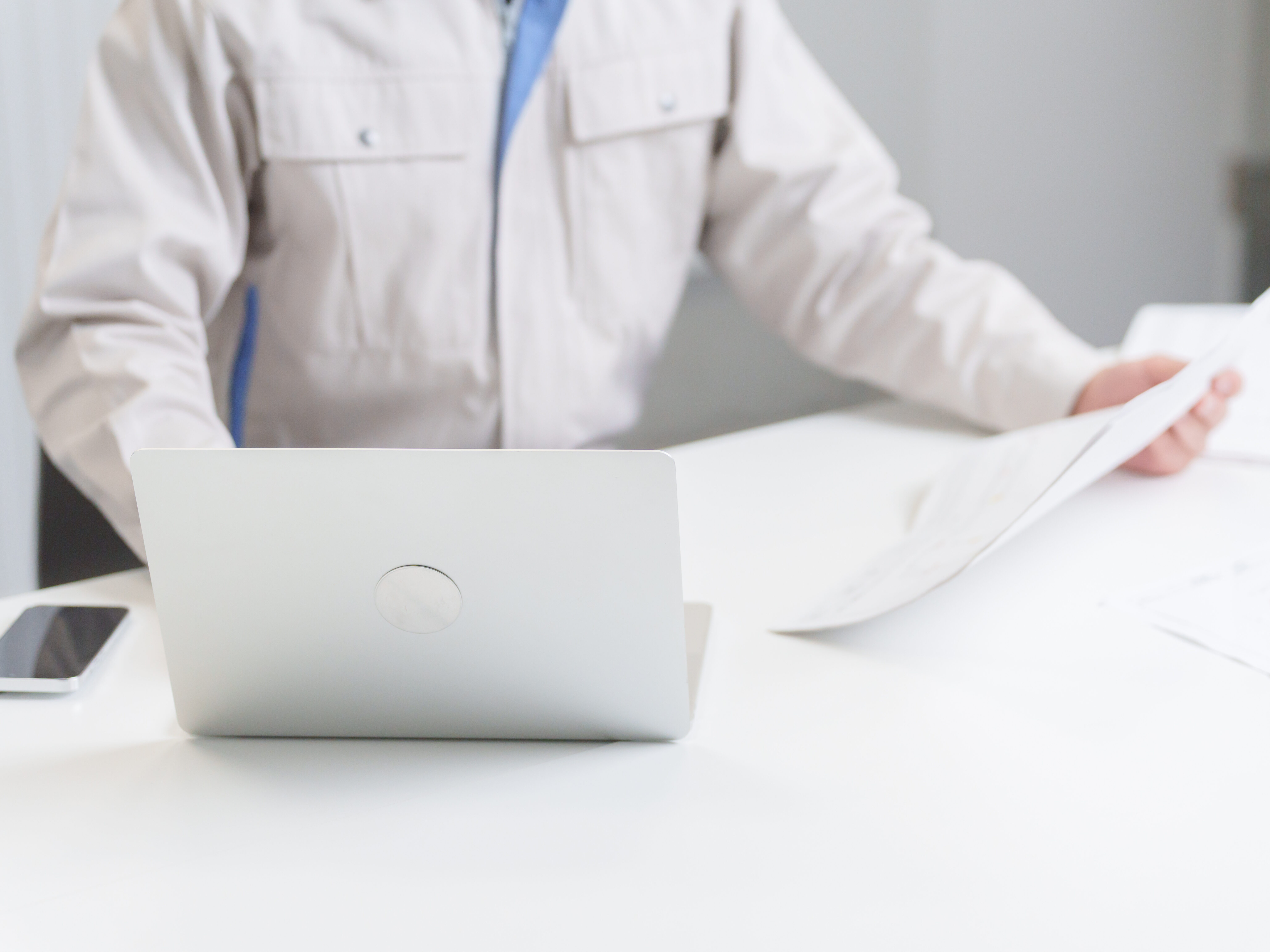 図面を確認する作業服の男性